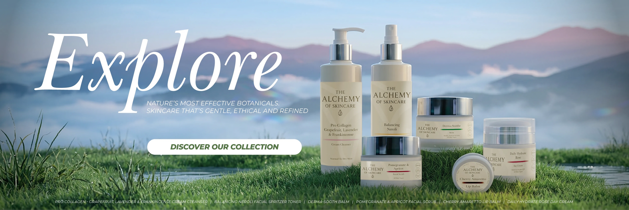 A promotional banner for Alchemy Naturals skincare, featuring several products including pump bottles, jars, and a round tin arranged on a grassy field with a mountain backdrop. Large white text on the left reads 'Explore' with smaller text below and a button that says 'DISCOVER OUR COLLECTION'.