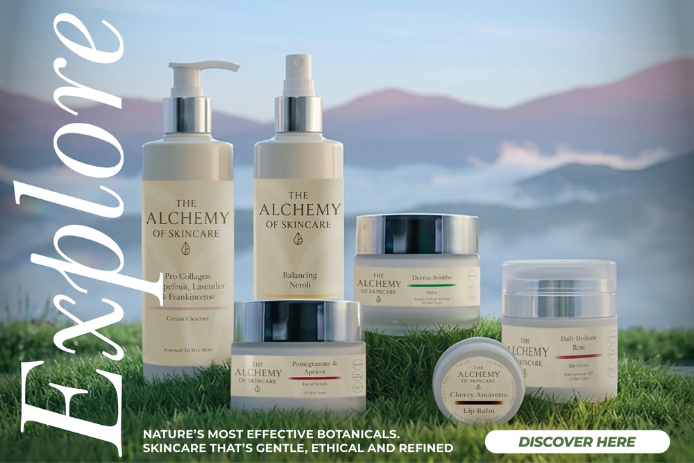 Six skincare products from The Alchemy of Skincare are arranged on a patch of green grass with a blurred mountain landscape in the background. Large vertical text reads 'Explore' on the left, and a banner at the bottom says 'NATURE'S MOST EFFECTIVE BOTANICALS.
