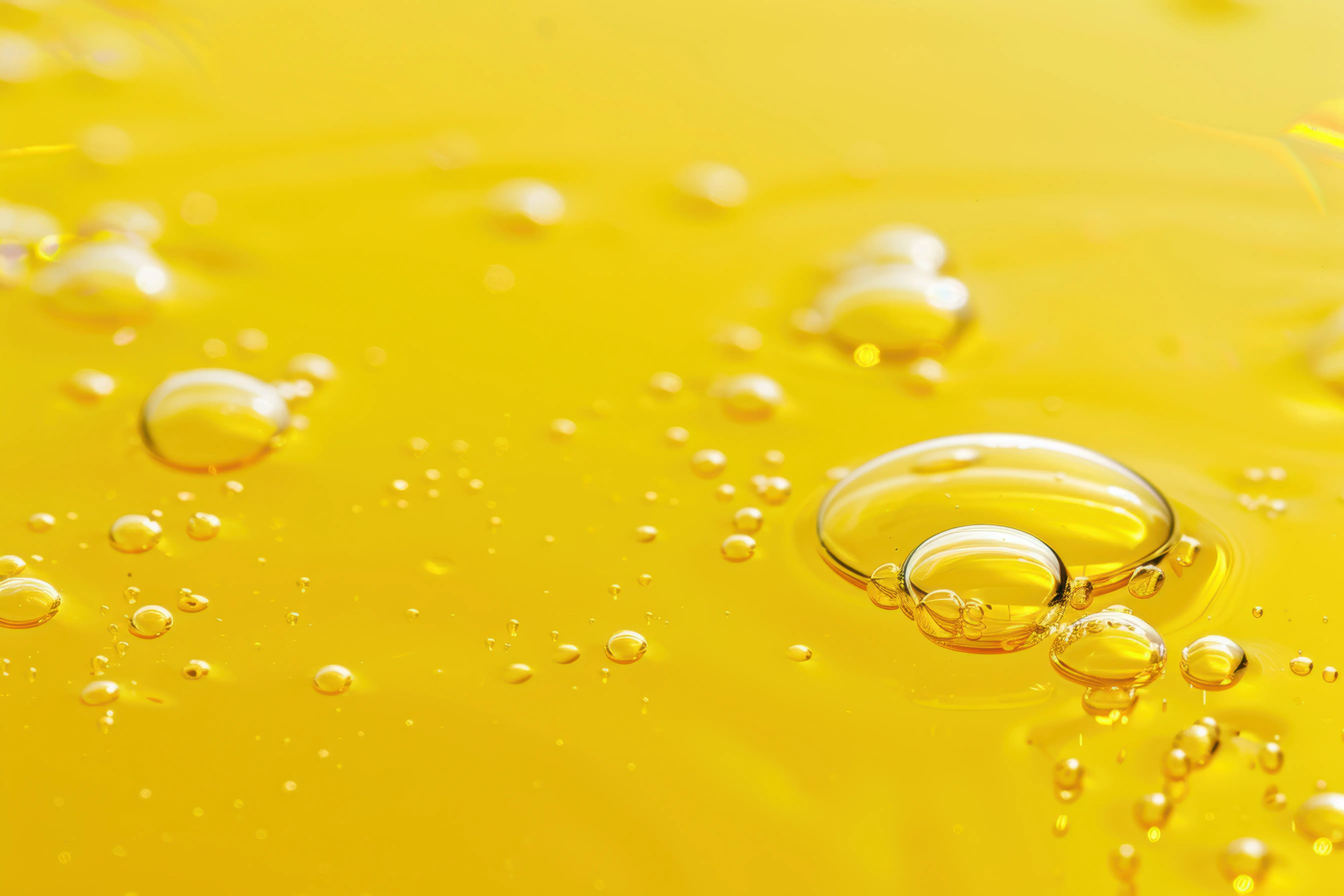 Bubbles of vitamin E oil on a yellow background 