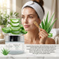 Woman applying aloe vera gel mask with aloe vera leaves and product packaging in the foreground.