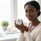 woman holding up facial cleansing balm