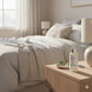 Bottle of Alchemy skincare product on a nightstand in a bedroom setting