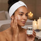 woman holding alchemy night cream and applying it to her face