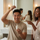 Man applying hair product with a woman pointing at it in a bathroom setting